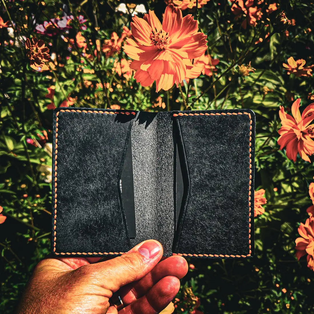 Black leather wallet with orange flowers background