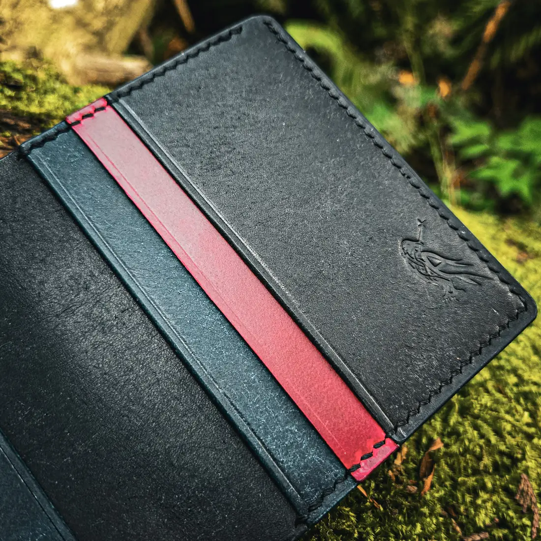 Handcrafted leather goods photographed on moss