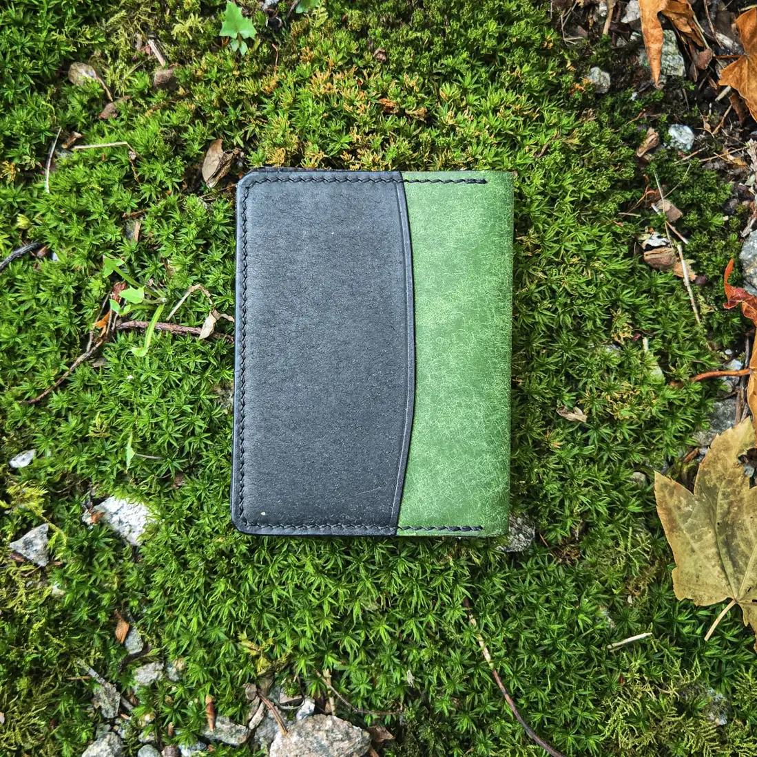 Handcrafted leather goods photographed on moss